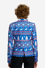 A person with curly hair is seen from behind, sporting the Suitmeister Christmas Jacket - Blue Nordic Jacket, which showcases a festive winter pattern of reindeer, trees, and snowflakes. They are also wearing black pants.