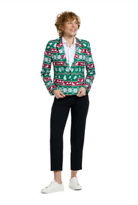 A person with curly hair smiles while wearing the Suitmeister Christmas Green Nordic Jacket, a festive blazer with holiday-themed patterns, along with a white shirt, black pants, and white sneakers, standing against a white background.