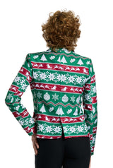 A person with curly hair stands confidently with their hand on their hip, showcasing the Suitmeister Christmas Green Nordic Jacket. This festive blazer is adorned with red, white, and green patterns featuring snowflakes, Christmas trees, and reindeer as they stand against a plain white background.