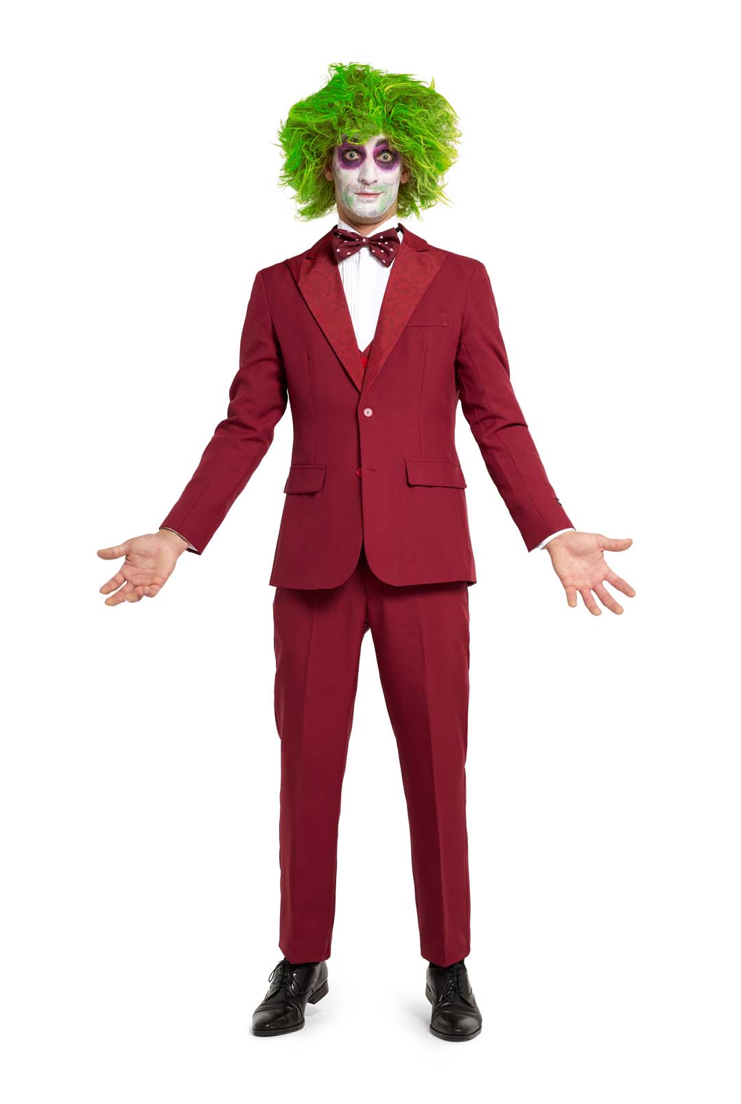 A person dressed in a Suitmeister Beetlejuice Groom costume, featuring a burgundy suit, green wig, and clown-like face paint, standing with arms open against a white background.