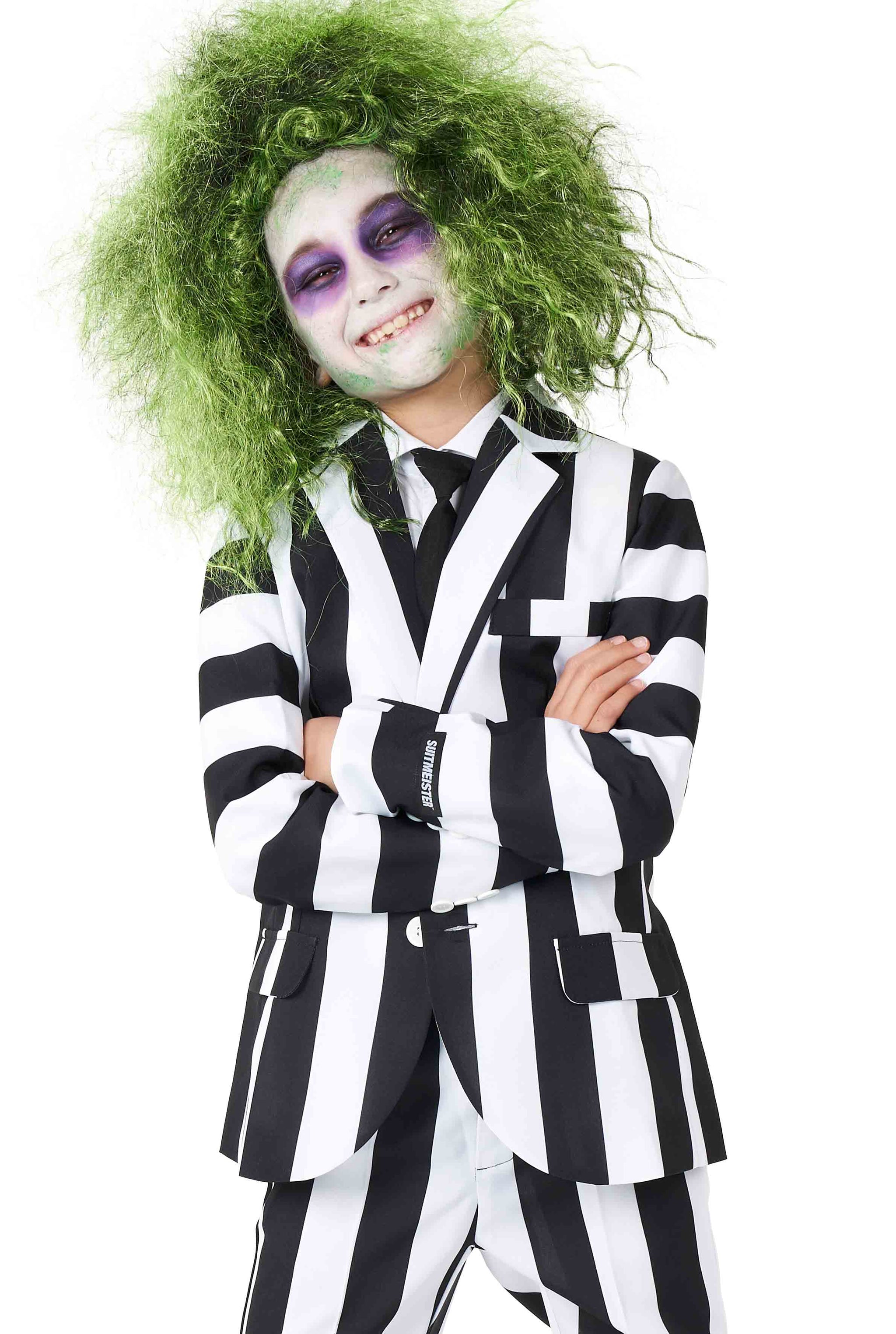 A person in a Beetlejuice suit by Suitmeister, complete with a green wig and purple makeup, smiles with arms crossed, exuding a playful, theatrical appearance.