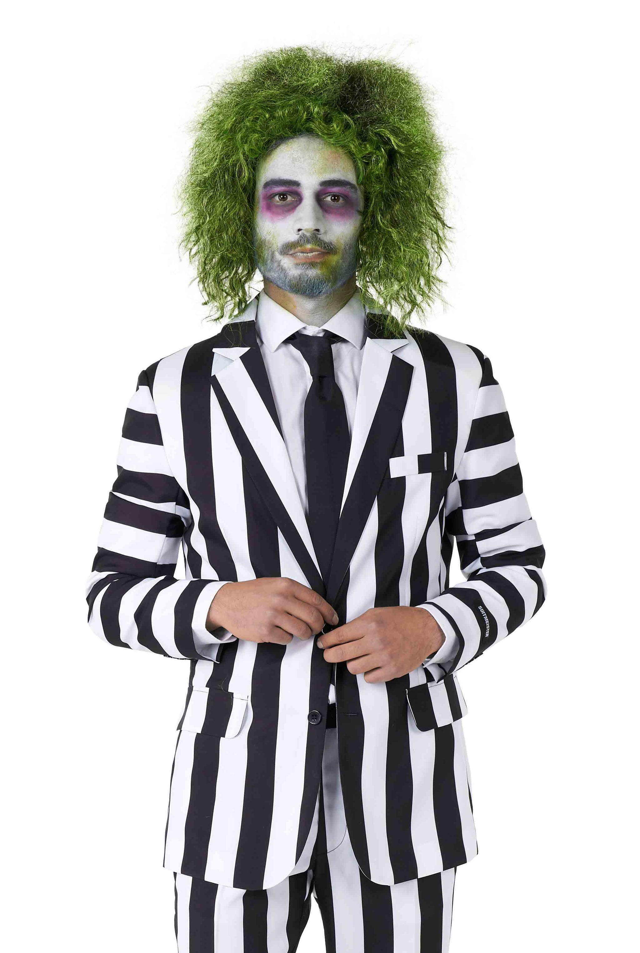 A person dressed in the Beetlejuice costume by Suitmeister, featuring a black and white striped suit with a tie, green messy hair, and face makeup resembling a ghoulish character, stands against a white background.