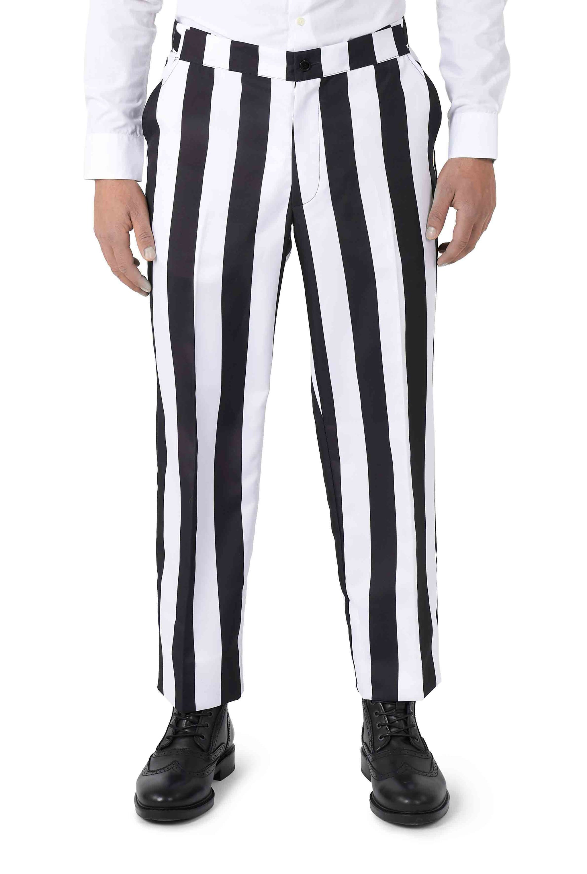 A person dressed in the Suitmeister Beetlejuice costume, featuring black and white vertically striped pants and a white shirt, stands facing forward while paired with black shoes.