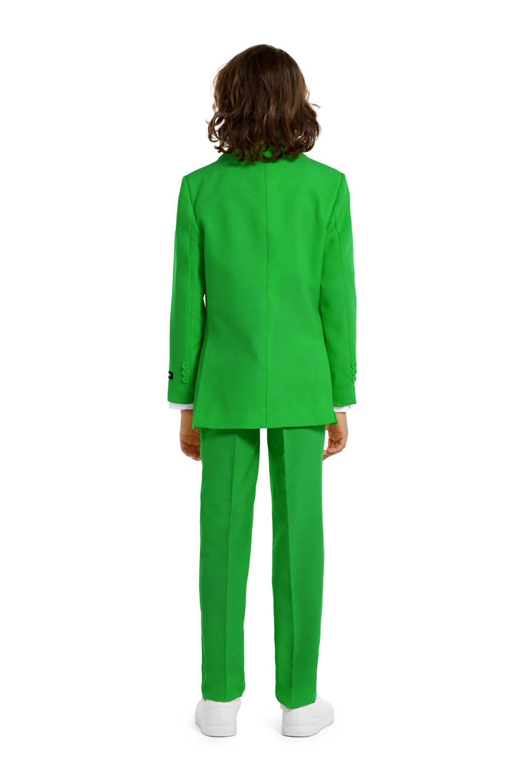 A child with long hair, dressed in a Suitmeister Solid Green suit and white sneakers, stands facing away against a plain white background.