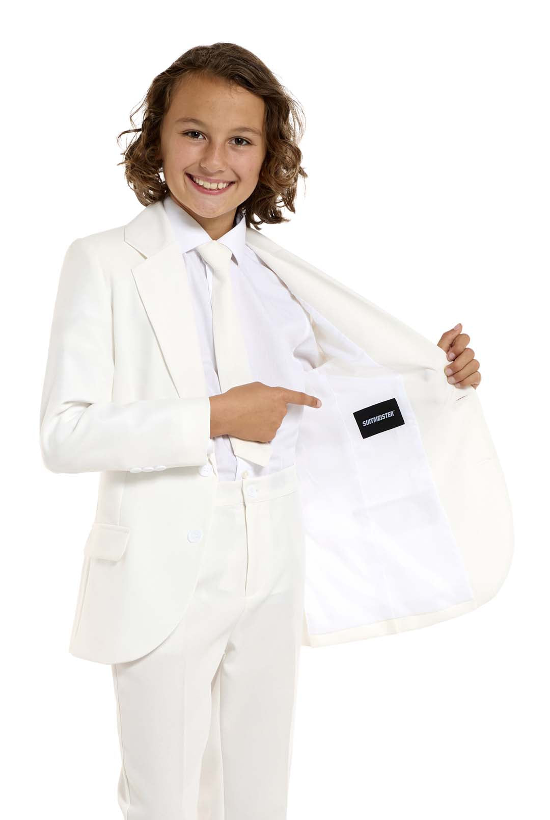 A young person smiles while pointing to the inside label of their Solid White suit by Suitmeister. The plain white background highlights both the individual and the stylish suit.