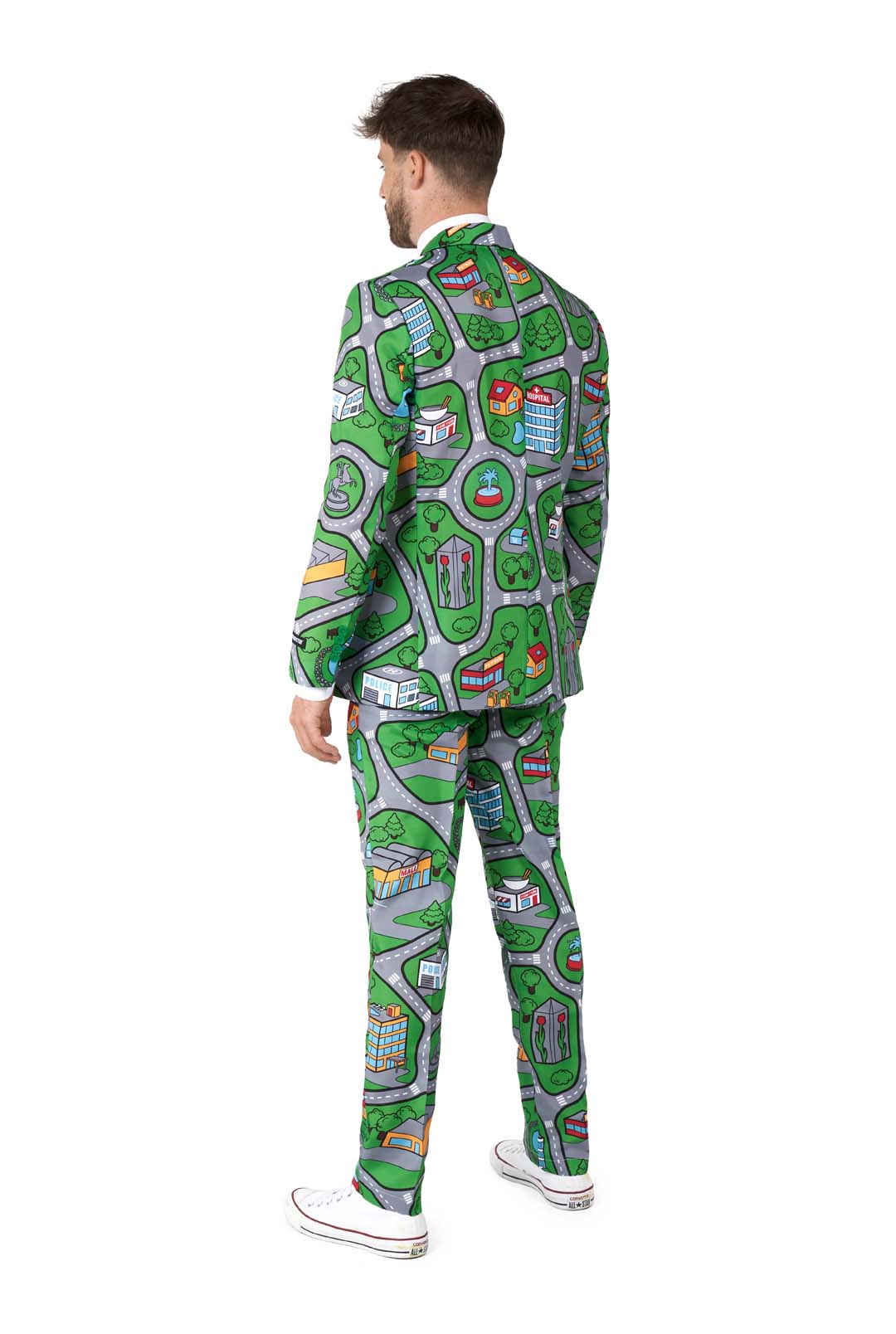 A person dressed in the Suitmeister Carpet City Green - Play Carpet suit, which features a whimsical, map-like print showcasing roads, buildings, and green spaces. The outfit includes both a matching jacket and pants. The individual is standing with their back turned while also sporting white sneakers.