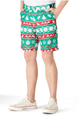 A person wearing a festive ensemble called the "Christmas Green Nordic" suit by Suitmeister, featuring a Christmas-themed pattern with trees, snowflakes, and reindeer in green, red, and white. The outfit is completed with white sneakers.