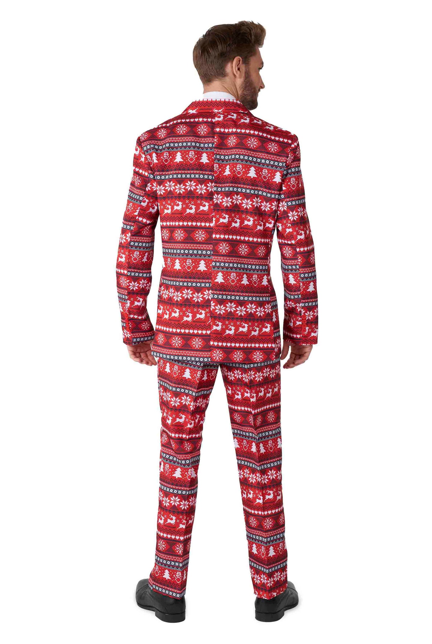 A person stands facing away, dressed in the Suitmeister Nordic Pixel Red - Christmas suit, showcasing a festive red and white holiday pattern adorned with snowflakes and reindeer. The ensemble includes both a jacket and trousers, complemented by black shoes.