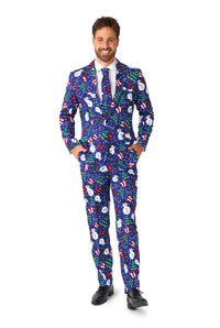 A person is dressed in the Suitmeister "Christmas Snowman Blue," a festive suit adorned with snowmen, candy canes, and snowflakes patterns. They are smiling, have their hands in their pockets, and are wearing a white shirt, a colorful tie, and black shoes.