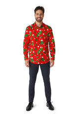 A man stands smiling, wearing the Suitmeister "Christmas Trees Stars Red" shirt adorned with green Christmas trees and white stars. He pairs it with dark pants and black shoes, standing against a plain white background.