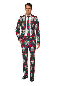 A person is dressed in the Suitmeister "Day of the Dead - Halloween suit," featuring a vibrant skull and rose design. The ensemble includes a matching tie and a white shirt, set against a plain white background.