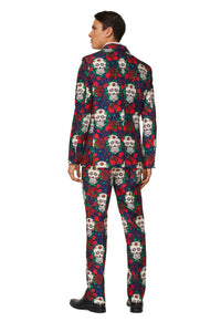 A person wearing the Day of the Dead - Halloween suit by Suitmeister, showcasing a colorful sugar skulls and roses design with vibrant reds, blues, and whites. They are standing and facing away in black shoes.