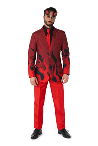 A man dressed in the Devil Red Halloween suit by Suitmeister is adorned with vivid flame designs on the jacket, complemented by a black shirt and a matching red tie. He accessorizes his look with striking red devil horns and finishes it off with sleek black shoes.