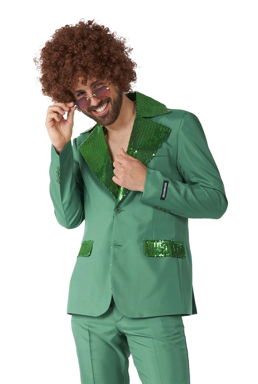 A person with curly hair wears the Disco Suit Green by Suitmeister, showcasing its retro style with sequined lapels and pocket accents. They are smiling and adjusting their sunglasses.