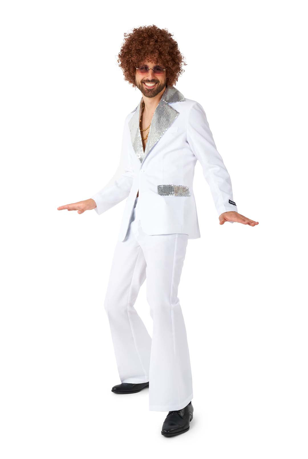 A person wearing the Disco Suit White by Suitmeister, complete with a glittery collar and pocket, curly wig, sunglasses, and gold jewelry, strikes a playful pose against a white background.