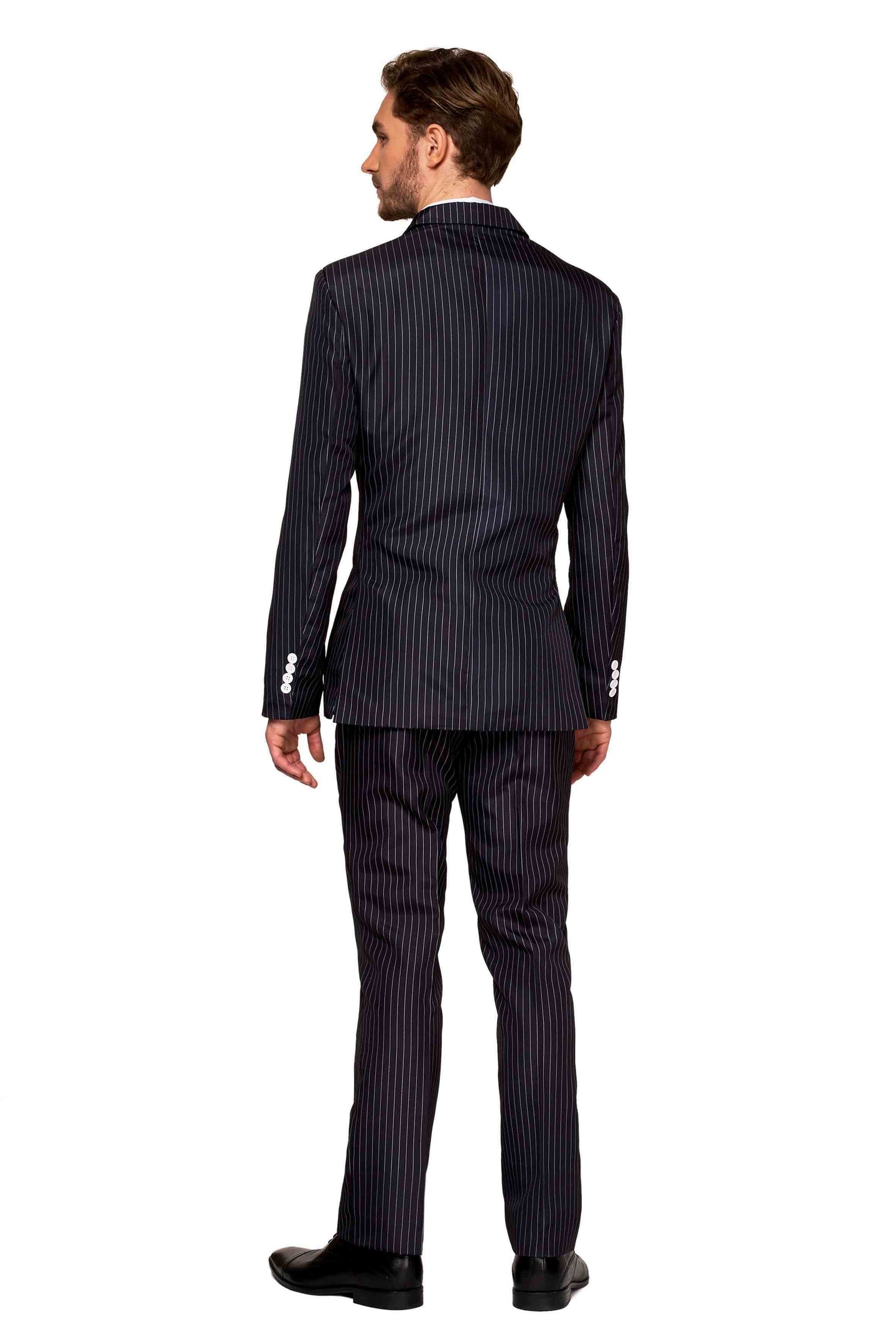 A man with brown hair stands facing away, wearing the Gangster Pinstripe Black suit by Suitmeister and black shoes. The suit jacket features white buttons on the cuffs, and he stands on a white background.