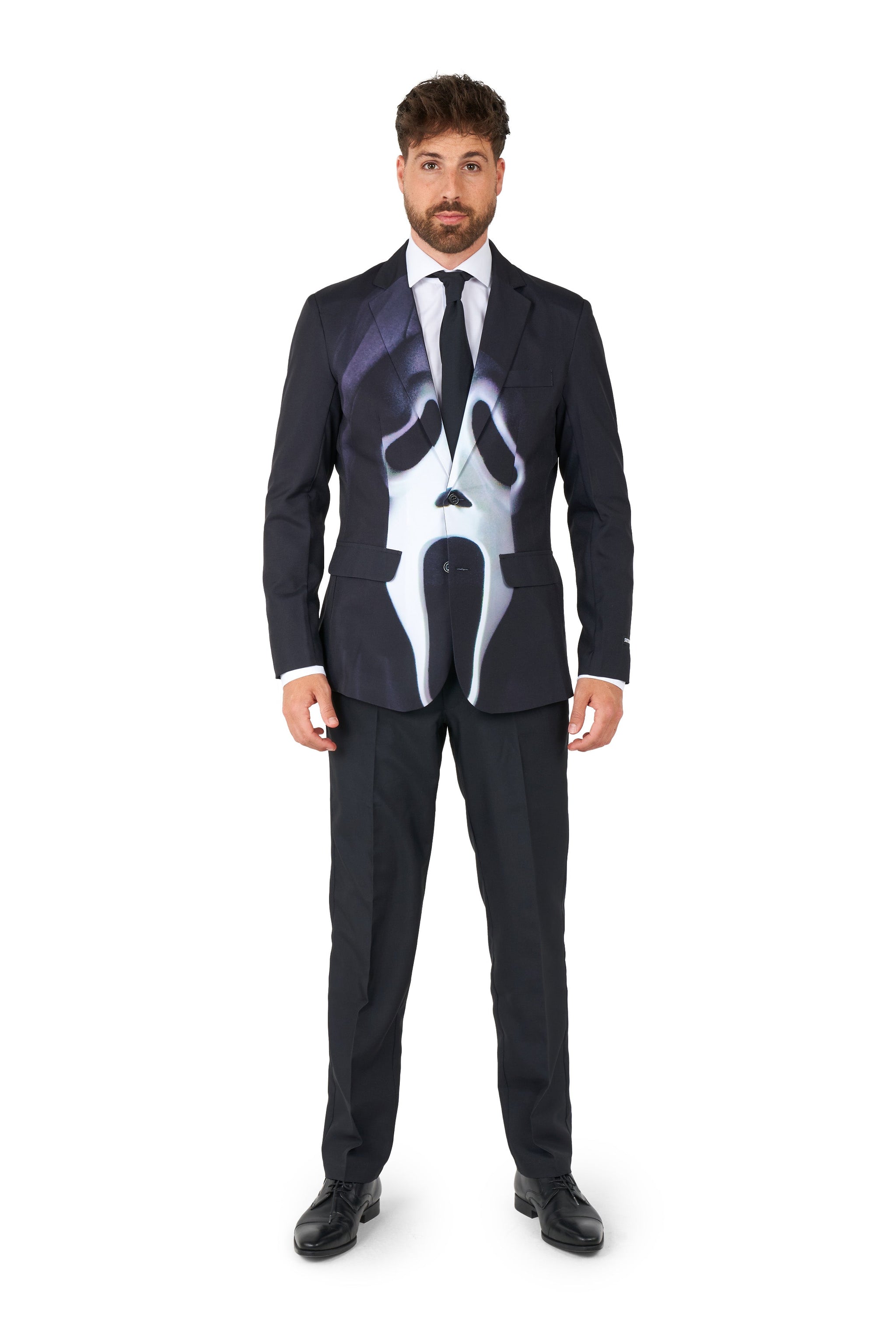 A man in a Suitmeister Ghostface suit with a stylized skeleton design on the jacket stands against a white background. He has brown hair and a beard. The black suit features a white skeleton print, complemented by his black tie and dress shoes.