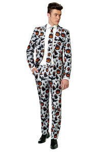 A man is dressed in Suitmeister's Halloween Grey Icons suit, adorned with black and orange pumpkin, bat, and ghost patterns on a white background. He complements the ensemble with a white shirt, a black tie, and black shoes while standing against a plain white backdrop.