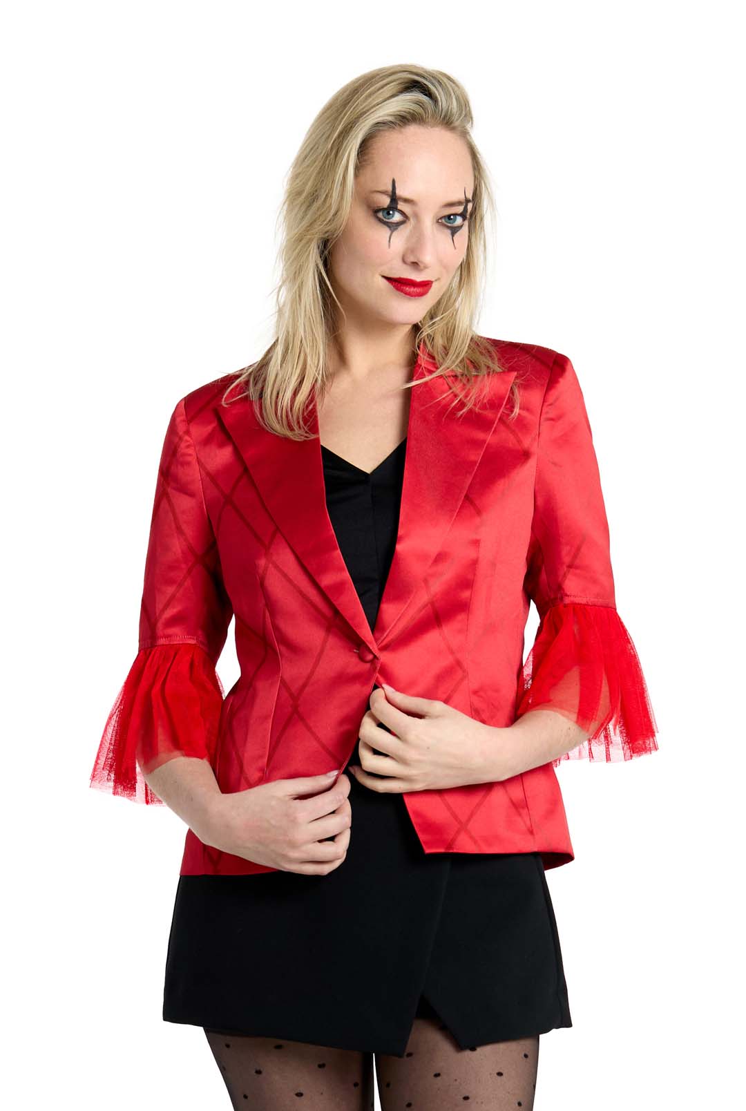 A woman with light hair is wearing Harley Quinn™ clown-style makeup, featuring star-like designs around her eyes. She is dressed in a Suitmeister red jacket with sheer ruffled sleeves and a black dress, standing against a plain white background.