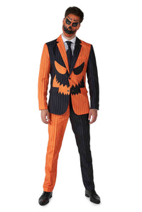 A man dressed in the Suitmeister Jack-O Pinstripe Black Halloween suit, showcasing a distinctive design with one side orange and the other black, adorned with a jack-o-lantern face. His facial makeup mirrors the suit's color scheme with intricate black and orange patterns.