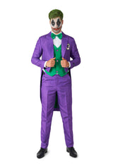 A person wearing the Joker™ Tailcoat Suit Purple from Suitmeister stands confidently, showcasing a look complete with green hair and clown-inspired face paint. The outfit is accessorized with a green vest and bow tie, all while they display a playful expression.