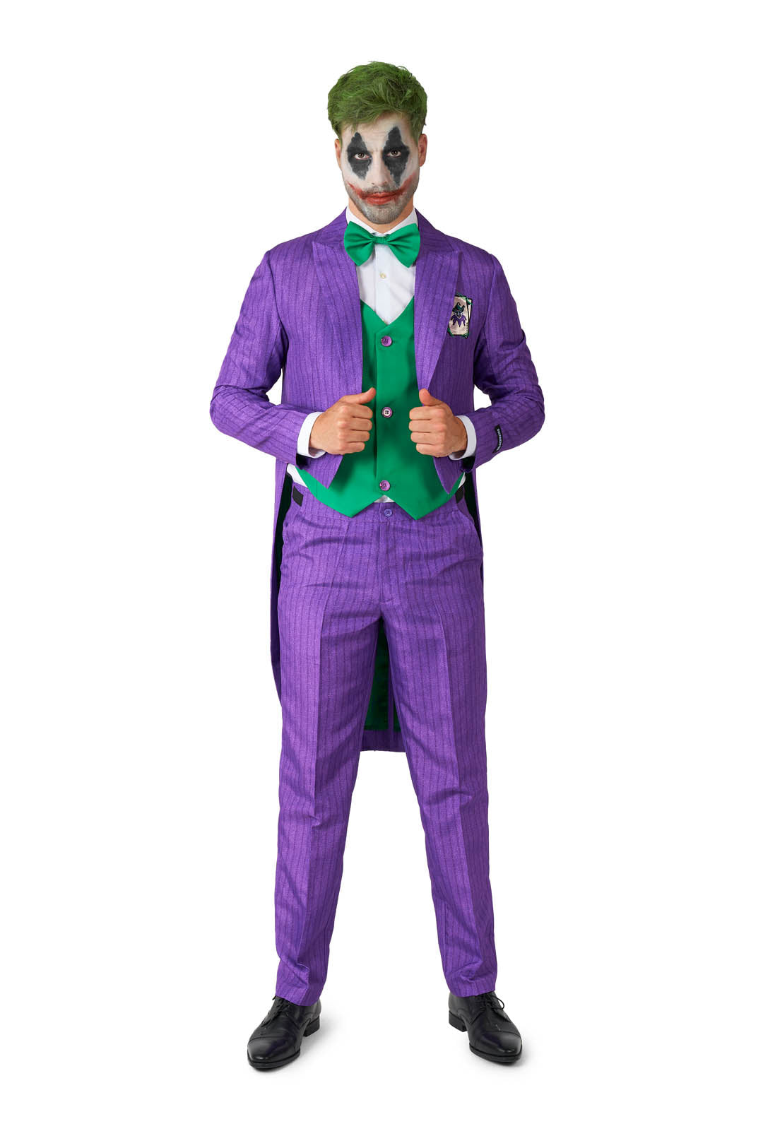 A person wearing the Joker™ Tailcoat Suit Purple from Suitmeister stands confidently, showcasing a look complete with green hair and clown-inspired face paint. The outfit is accessorized with a green vest and bow tie, all while they display a playful expression.