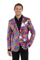 A person in a Suitmeister Rainbow Sequin Blazer and a black shirt smiles with hands in pockets against a white background.