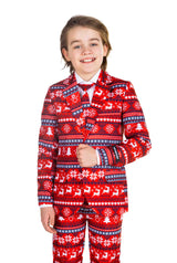 A smiling child dressed in the Suitmeister Nordic Pixel Red Christmas suit, showcasing a festive pattern of reindeer, snowflakes, and trees in red, white, and black. They complete the outfit with a crisp white shirt and a vibrant red tie.