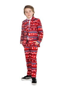 A young boy stands confidently with hands in pockets, showcasing the Nordic Pixel Red Christmas suit by Suitmeister. The festive attire is adorned with snowflakes and reindeer patterns. He complements his look with a white shirt, tie, and black sneakers against a plain white background.