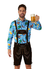 A man in traditional Bavarian attire holds a mug of beer while wearing the "October Check Blue - Octoberfest shirt" by Suitmeister, featuring beer and pretzel designs with dark lederhosen, and he's smiling.