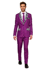 A man dressed in a vibrant Suitmeister "Pimp" purple suit, featuring zebra print accents on the lapels, pockets, and tie, paired with a crisp white shirt and black shoes.