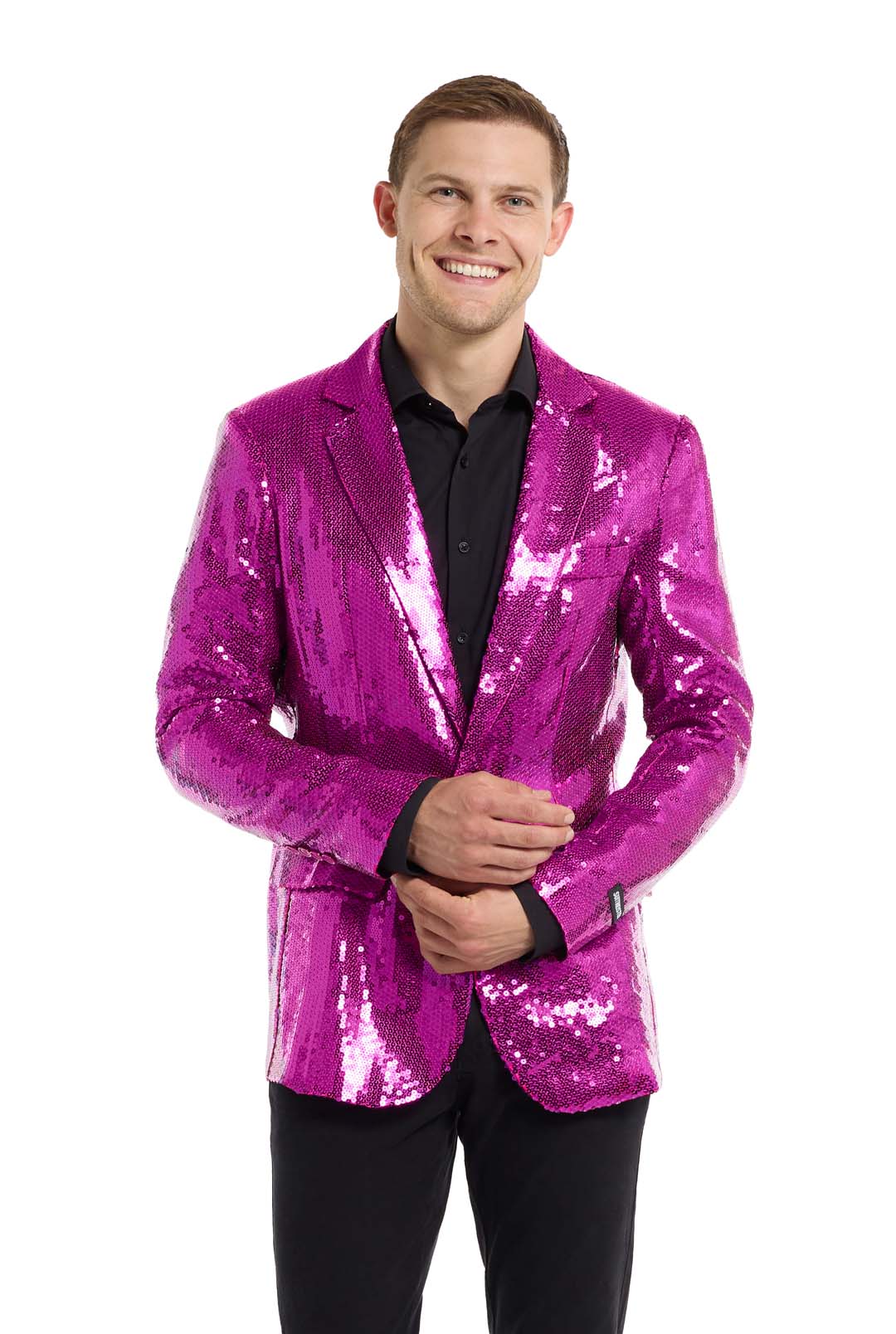 A person smiling and wearing a Suitmeister Sequins Blazer Pink over a black shirt, against a plain white background. They are holding the cuff of their blazer with one hand.