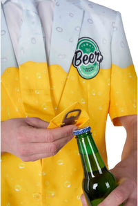 A person wearing the Suitmeister "Premium Beer Yellow" suit, which showcases a beer-themed design, uses a small silver bottle opener to open a green beer bottle. The suit prominently displays the Beer logo on the chest.