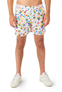 A person is wearing the Pride Icons White - Pride outfit by Suitmeister, featuring white shorts adorned with colorful patterns such as rainbows, stars, and hearts. Paired with white sneakers, the image captures a casual look from the waist down.