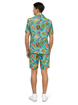 A man wearing the Suitmeister "Retro Blue 90’s Icons - Carnival suit," which includes a vibrant shirt and matching shorts adorned with geometric shapes in bright colors, stands facing away. He completes the look with white sneakers against a plain white background.