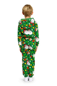 The child is dressed in a Suitmeister's Santa Elves Green - Christmas Onesie, which features Santa Claus, gifts, and stars, and includes a hood. The child stands facing away while wearing white socks.