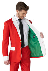 A man dressed in the Suitmeister Santa Faux Fur - Santa Christmas suit, complete with a white shirt and black tie, reveals the green lining of his red jacket, which features a white trim reminiscent of a classic Santa outfit.