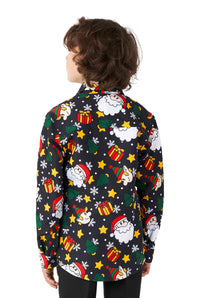 A child is wearing the Suitmeister Santa Elves Black - Christmas shirt, which features a festive and colorful design with holiday-themed prints of Santa, stars, and presents against a black background. The child is facing away to showcase the vibrant design.