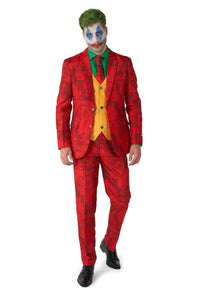 The person is wearing the Scarlet Joker™ ensemble, designed by Suitmeister, featuring a bright red suit paired with a yellow vest and green shirt. Their look is completed with a brightly painted face.