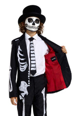 A person wearing Suitmeister's Skeleton Grunge Black ensemble, complete with a black top hat. The suit jacket is open to show off its red lining, and the tie echoes the skeleton design. Their face is painted to resemble a skull.