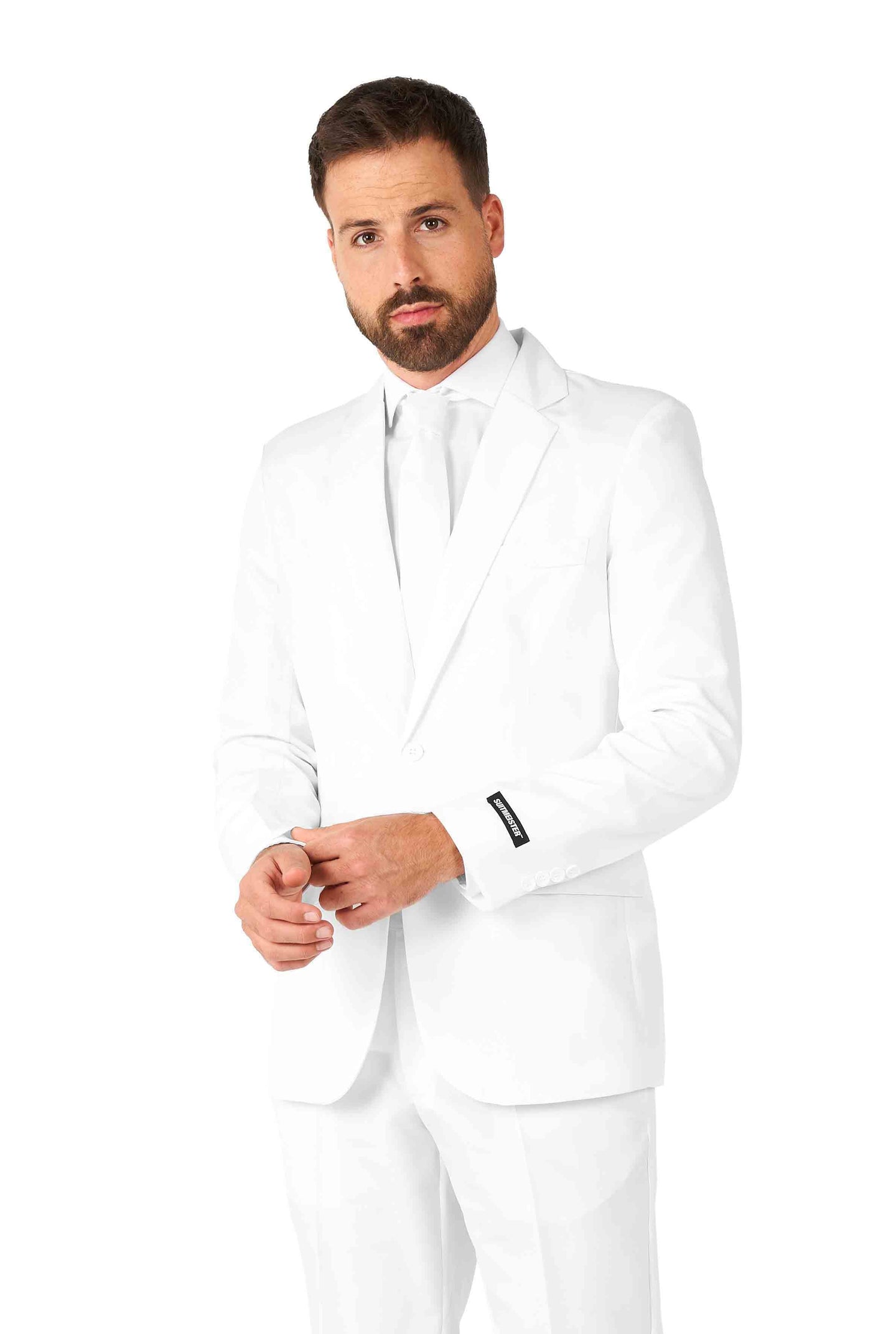 A man with a beard is wearing a Suitmeister Solid White suit and tie, standing against a plain white background. He has a thoughtful expression on his face and is holding his hands in front of him.