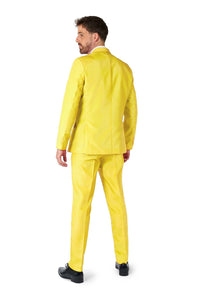 Wearing the Solid Yellow suit by Suitmeister, a man stands facing away with his head turned slightly to the side. He pairs the outfit with black shoes against a plain white background.