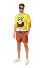 A person wearing sunglasses is dressed in a vibrant yellow SpongeBob™ shirt by Suitmeister, featuring a smiling cartoon character face, along with brown shorts, standing against a plain white background.