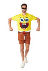 A man sporting sunglasses grins as he strolls. He's clad in a Suitmeister SpongeBob™ - SpongeBob outfit, featuring a yellow shirt with brown shorts, and complements it with white sneakers. His arms are bent and lifted as if he's in mid-step, set against a plain white background.