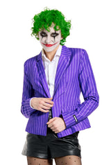 The individual is dressed in The Joker Jacket by Suitmeister, accompanied by a green wig and dramatic clown-inspired face paint. They wear a white shirt and black leather shorts, set against a plain white background.