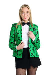 A person wearing The Riddler Jacket by Suitmeister, a green jacket with black question marks, is over a white shirt. They complement it with a black bow tie, a black skirt, and polka-dot stockings. Smiling, they hold the jacket with one hand.