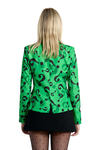 A person with long blond hair, viewed from behind, is wearing The Riddler Jacket by Suitmeister—a green blazer adorned with black question marks. Their ensemble is finished off with a black skirt and sheer black tights.