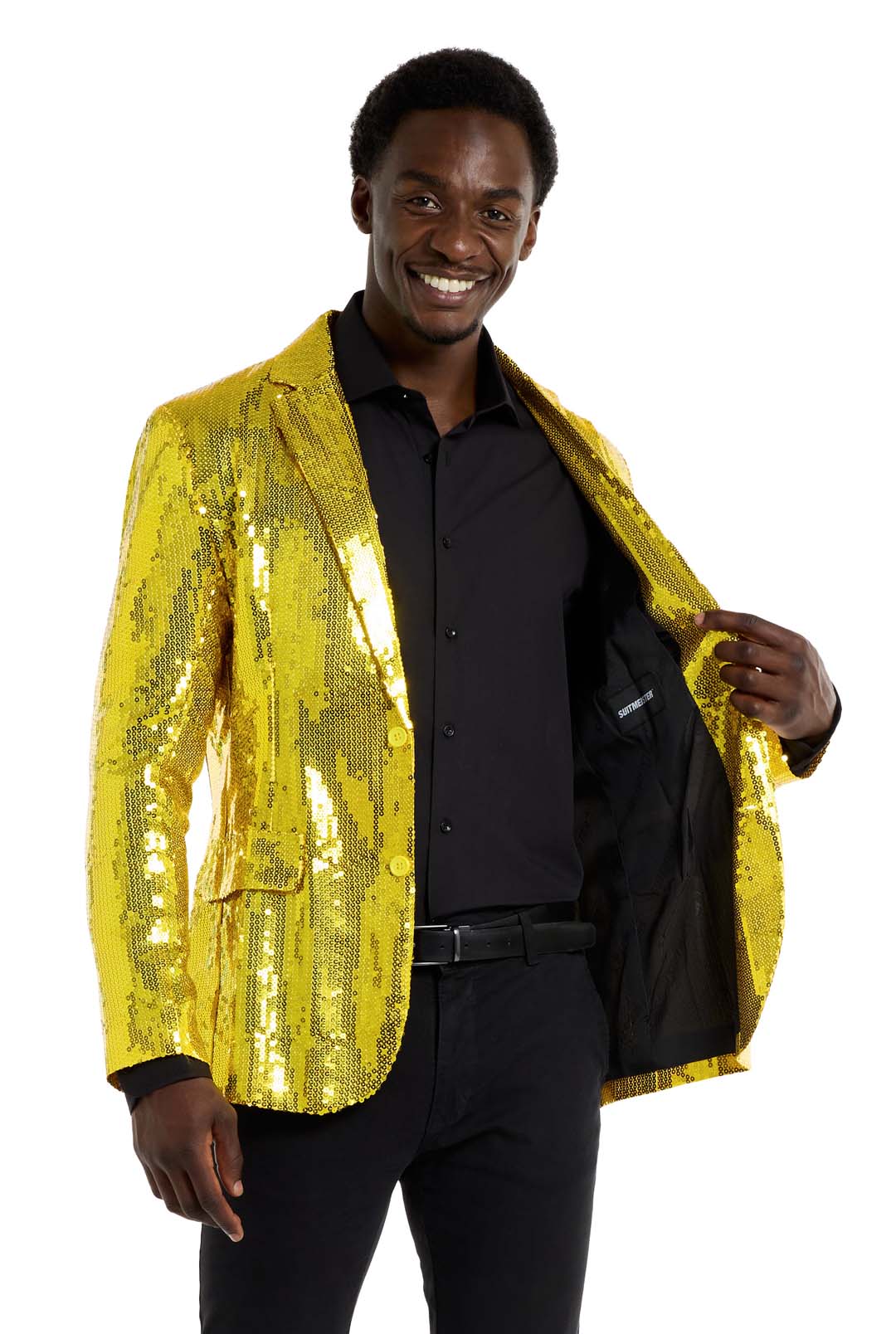 A person smiles while wearing the Sequins Blazer Yellow from Suitmeister over a black shirt and pants. The open blazer reveals its sleek black lining against a plain white backdrop.