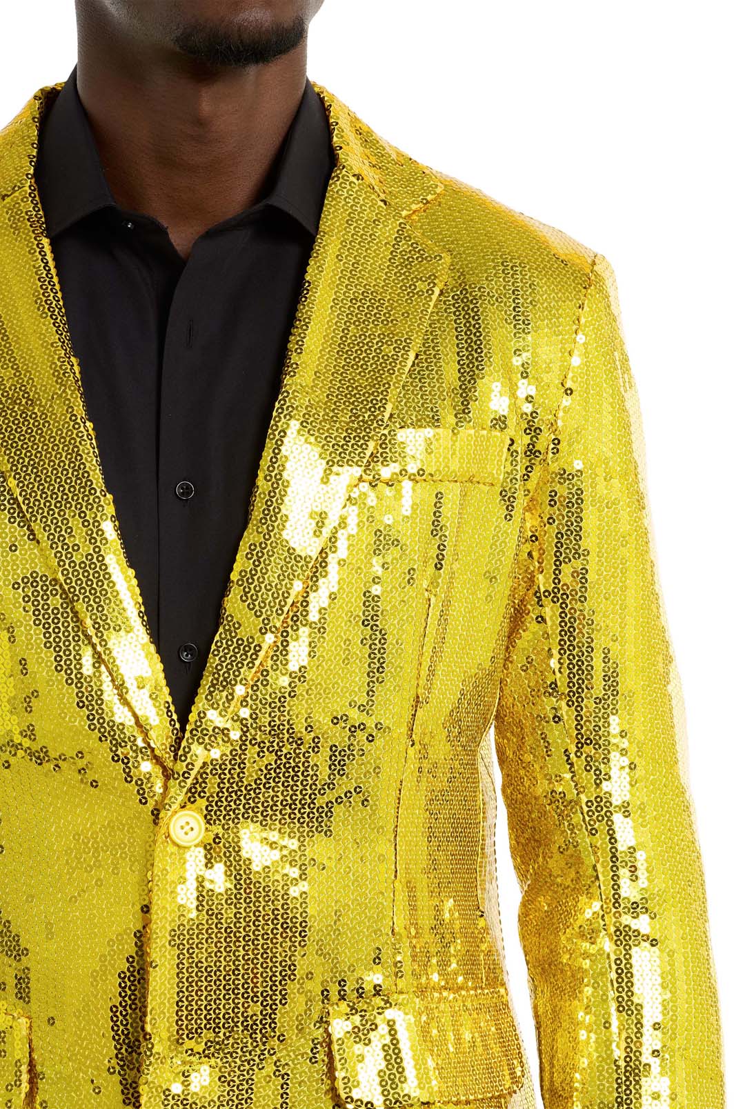 A person is wearing the Suitmeister Sequins Blazer in Yellow over a black shirt. The blazer is vibrant and reflective, catching the light with its sequins. The person’s face is not visible in the image.